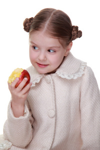 一个小女孩吃一个苹果的工作室肖像