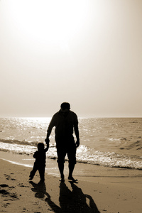 爸爸和孩子上海滩的日落