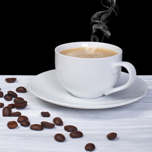 热咖啡与烟和咖啡豆木桌子上