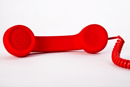 在白色背景上的红色经典电话耳机