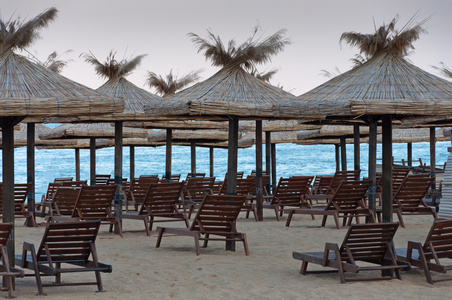 与太阳伞盖在海滩上的躺椅