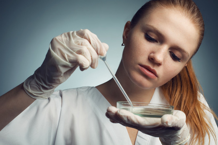 年轻女子用滴管在工作科学家的肖像