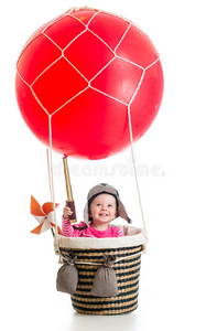 在热气球上戴着飞行员帽和遥控器的孩子
