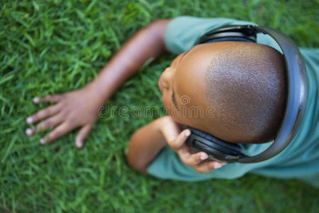 小男孩躺在草地上听音乐