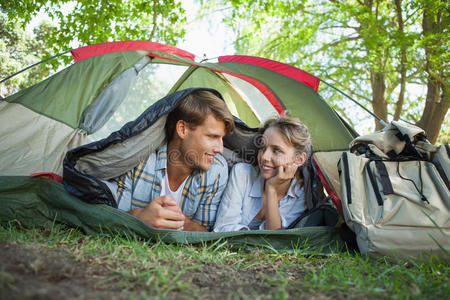 一对可爱的夫妇躺在帐篷里互相微笑