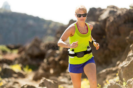 阳光明媚的夏日里在山上奔跑的年轻女子