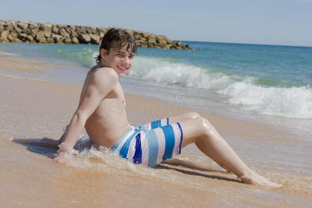 男孩在一个有着水晶水的美丽海洋里玩耍