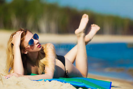 暑假穿比基尼的女孩在沙滩上晒太阳