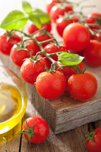 樱桃番茄罗勒和橄榄油木质背景