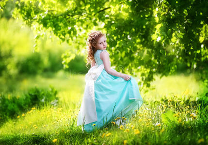一个漂亮的小女孩穿着蓝色的裙子，戴着一个白色的大蝴蝶结