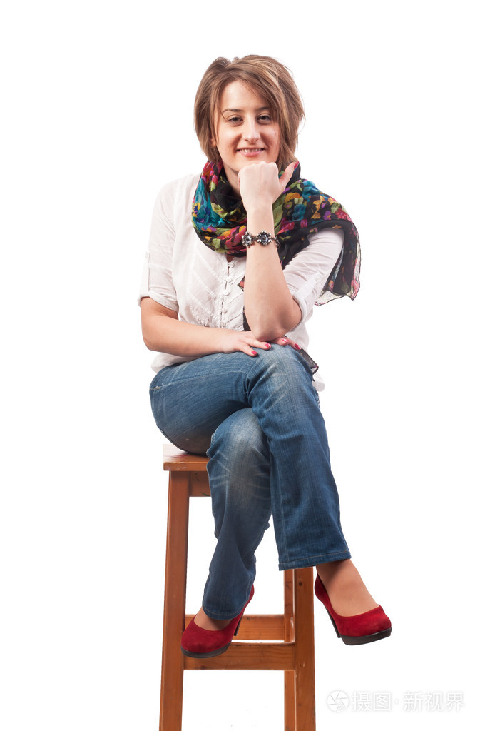 美丽微笑的年轻女子坐在一张椅子上