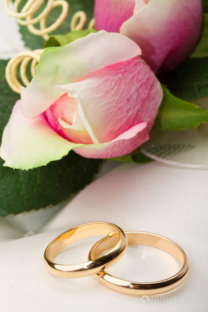 结婚戒指和粉红玫瑰