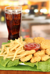 炸薯条, 可乐, 在咖啡厅中表上的酱汁鸡块男人吃炸鸡木制桌子上的炸鸡