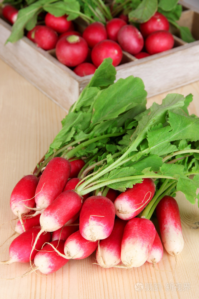 小萝卜与木制背景上的叶子