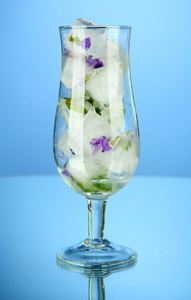 冰用鲜花和草药的玻璃，在蓝色背景上的多维数据集
