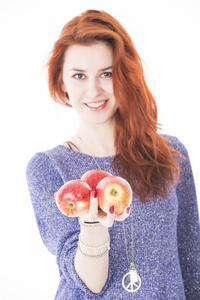 年轻女性举行三个红苹果