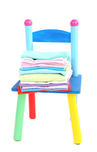 婴儿衣服隔绝在白色的小和多彩椅子