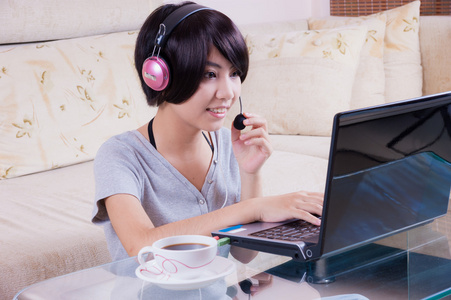 年轻的亚洲女孩使用的便携式计算机