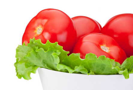 特写新鲜番茄配绿色沙拉叶在碗孤立 o