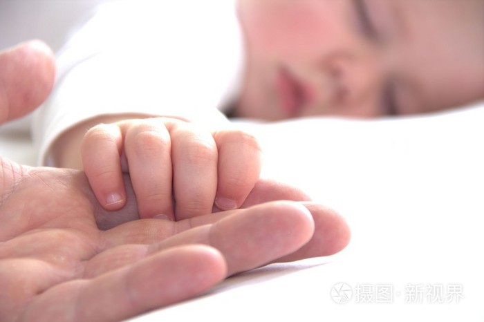 睡着蹒跚学步的男孩握着父亲的手