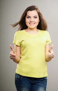 有吸引力的年轻女人在黄色上衣显示的拇指 u 的女人
