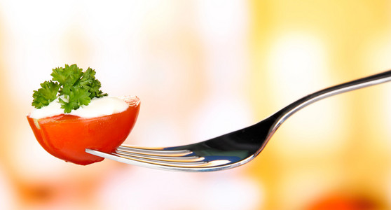 樱桃番茄黏附在叉子，在明亮的背景上