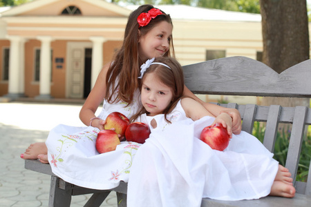 可爱女孩红苹果的长凳上篮