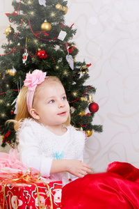 惊讶在圣诞树下的小女孩