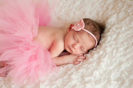 新生女婴身穿粉色钩的头带和图图