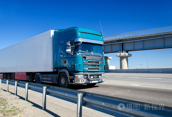 在公路上行驶的蓝色卡车