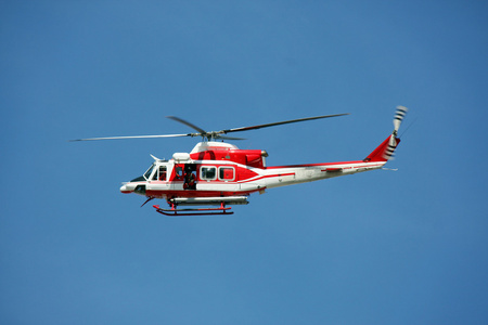 空中救护车消防员在火 9 上蓝色的天空中,巡逻直升机照片