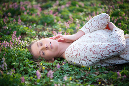 有吸引力的年轻女人，躺在草和鲜花