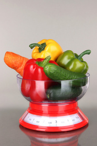 新鲜蔬菜在体重秤上的灰色背景