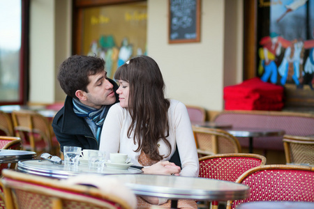 约会情侣接吻在巴黎咖啡馆