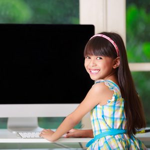 家里的电脑上的小亚洲女孩