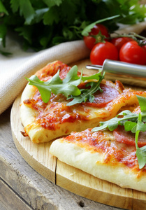 意大利辣香肠比萨饼配番茄汁和香草在木板上