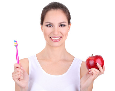 微笑与苹果和牙刷上白色隔离的女人