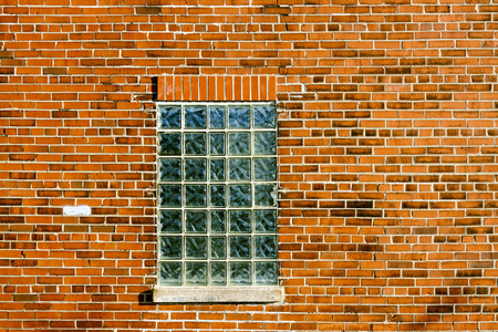 工业红砖墙壁与蓝色玻璃块窗口