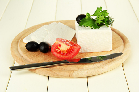 羊牛奶乳酪 黑橄榄 红番茄与欧芹和莳萝上切板 彩色木制背景上