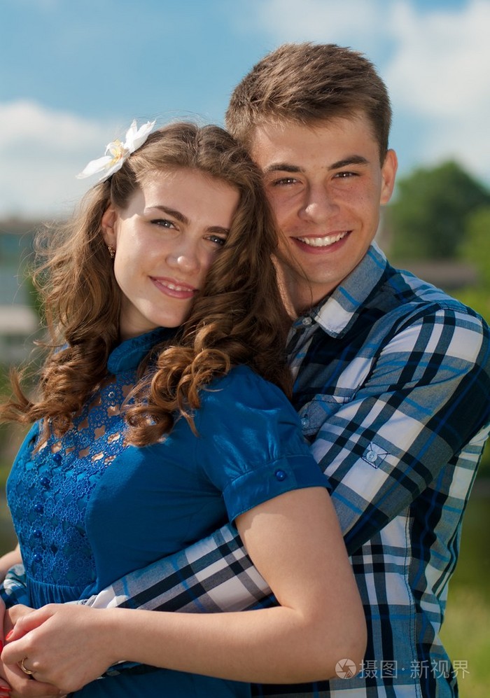 快乐的少女夫妻拥抱在蓝蓝的天空背景照片-正版商用图片1ce91z-摄图新