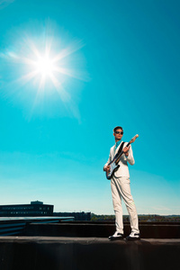 复古五十年代男性的吉他手与白色西装和 sunglasse