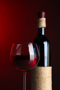 杯酒与瓶亮红色背景上
