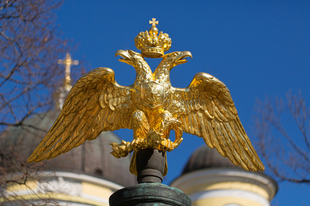 蓝蓝的天空的背景上的金色双头鹰照片