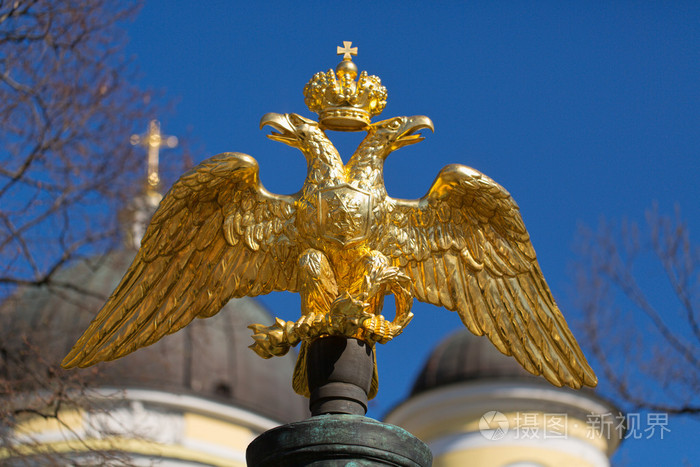 蓝蓝的天空的背景上的金色双头鹰