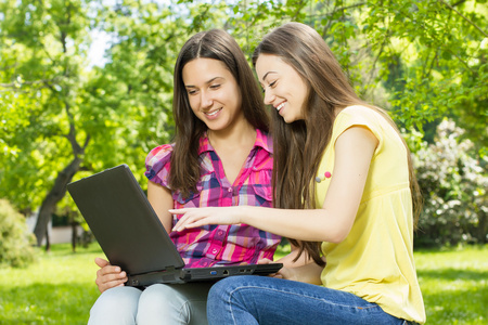 微笑着的女学生使用的便携式计算机
