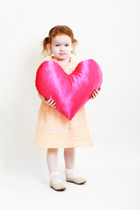小女孩用巨大明亮的红色的心图片