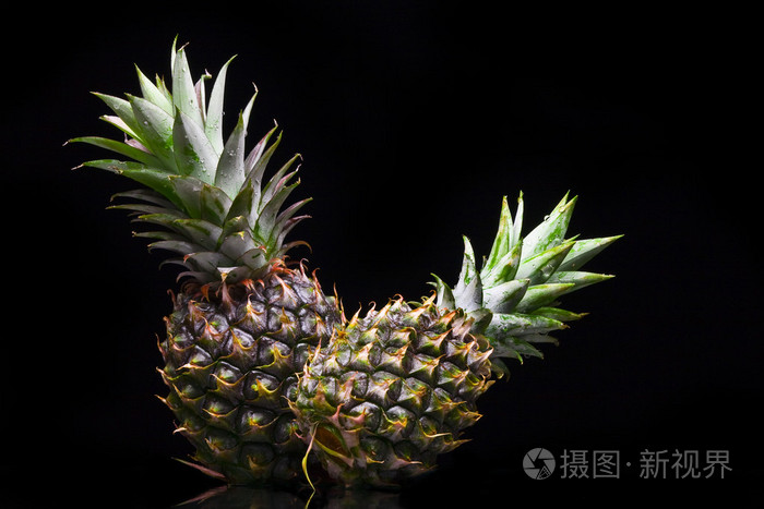 黑色背景上的两个好新鲜菠萝视图
