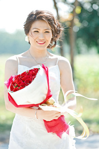 美丽的新娘户外与玫瑰花束