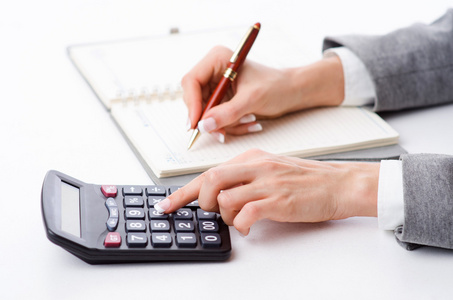 在计算器上工作的手照片