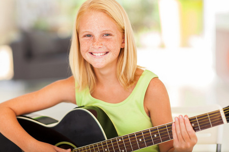 pre 十几岁的女孩练吉他在家里